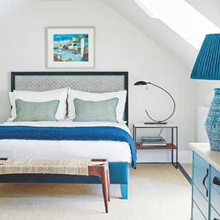 White bedroom with white bedding and blue accents and accessories around the room