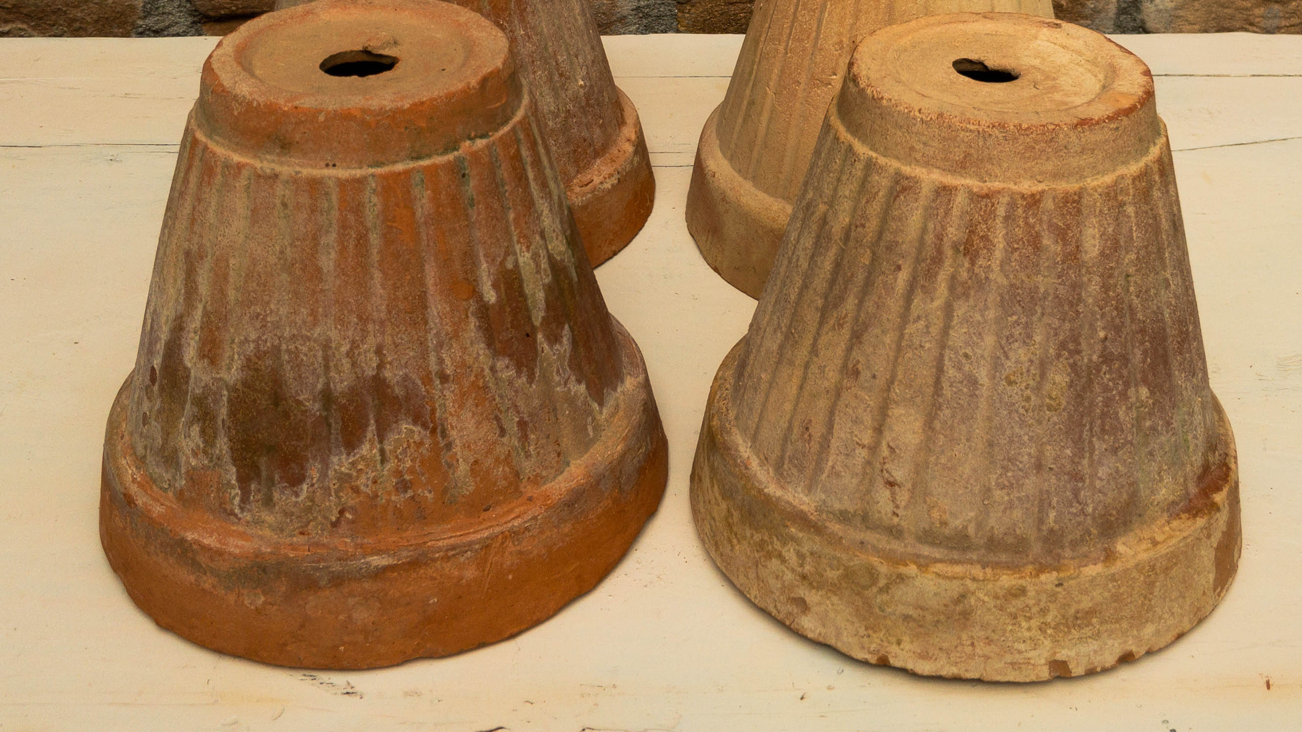 Four terracotta pots upside down