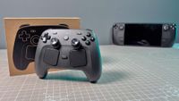 The Steam Controller on a desk in front of a Steam Deck.