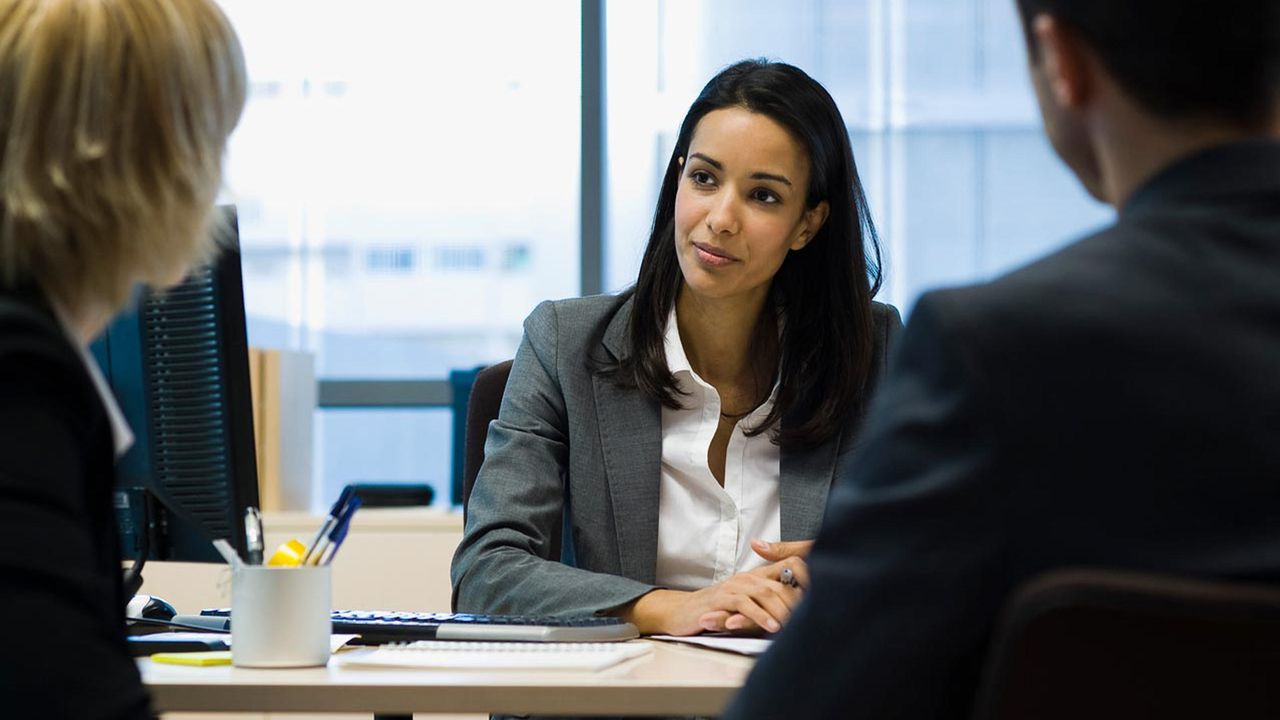 A financial adviser meets with two clients.