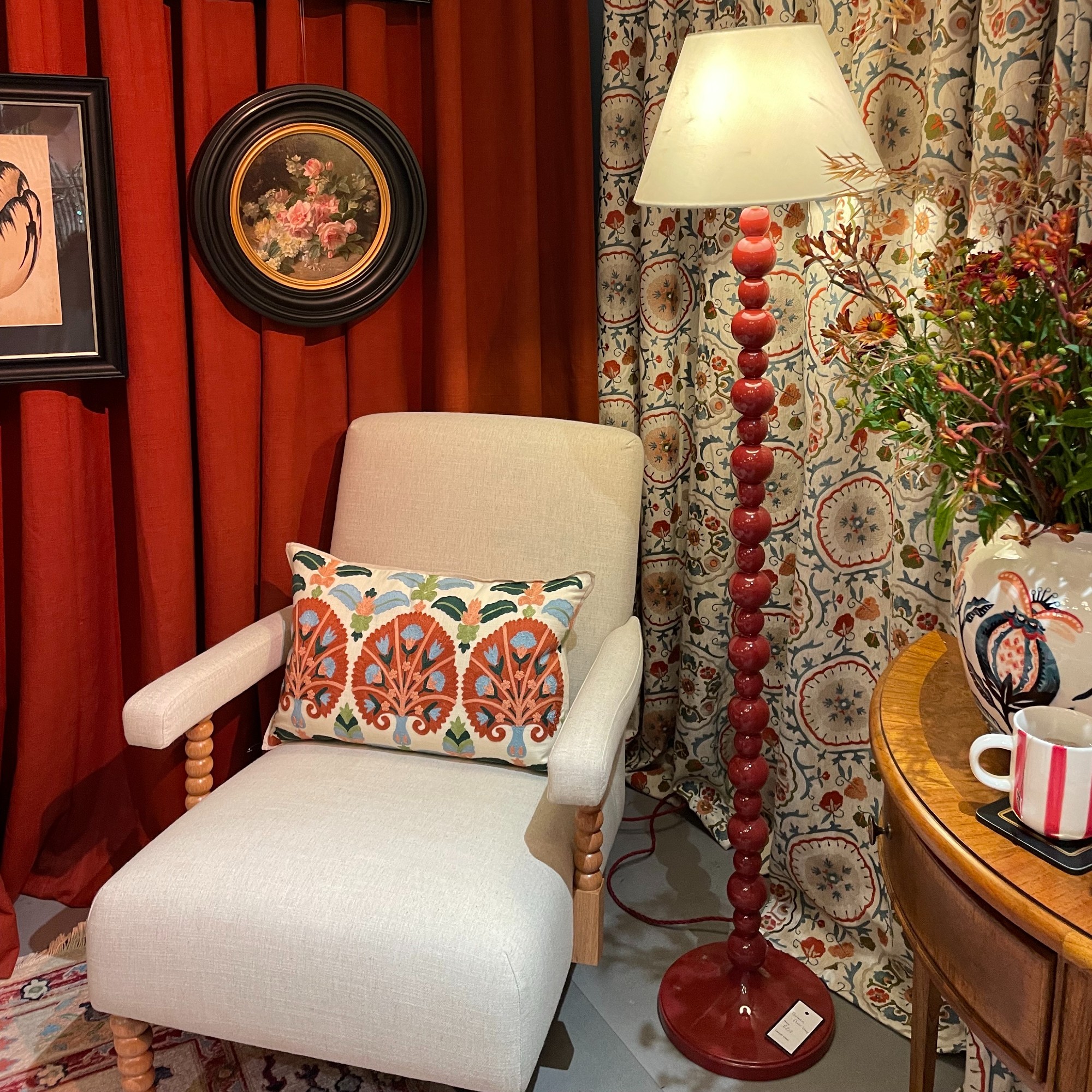 A living room set-up at the John Lewis autumn/winter 2025 press preview with a bobbin armchair and a red bobbin floor lamp
