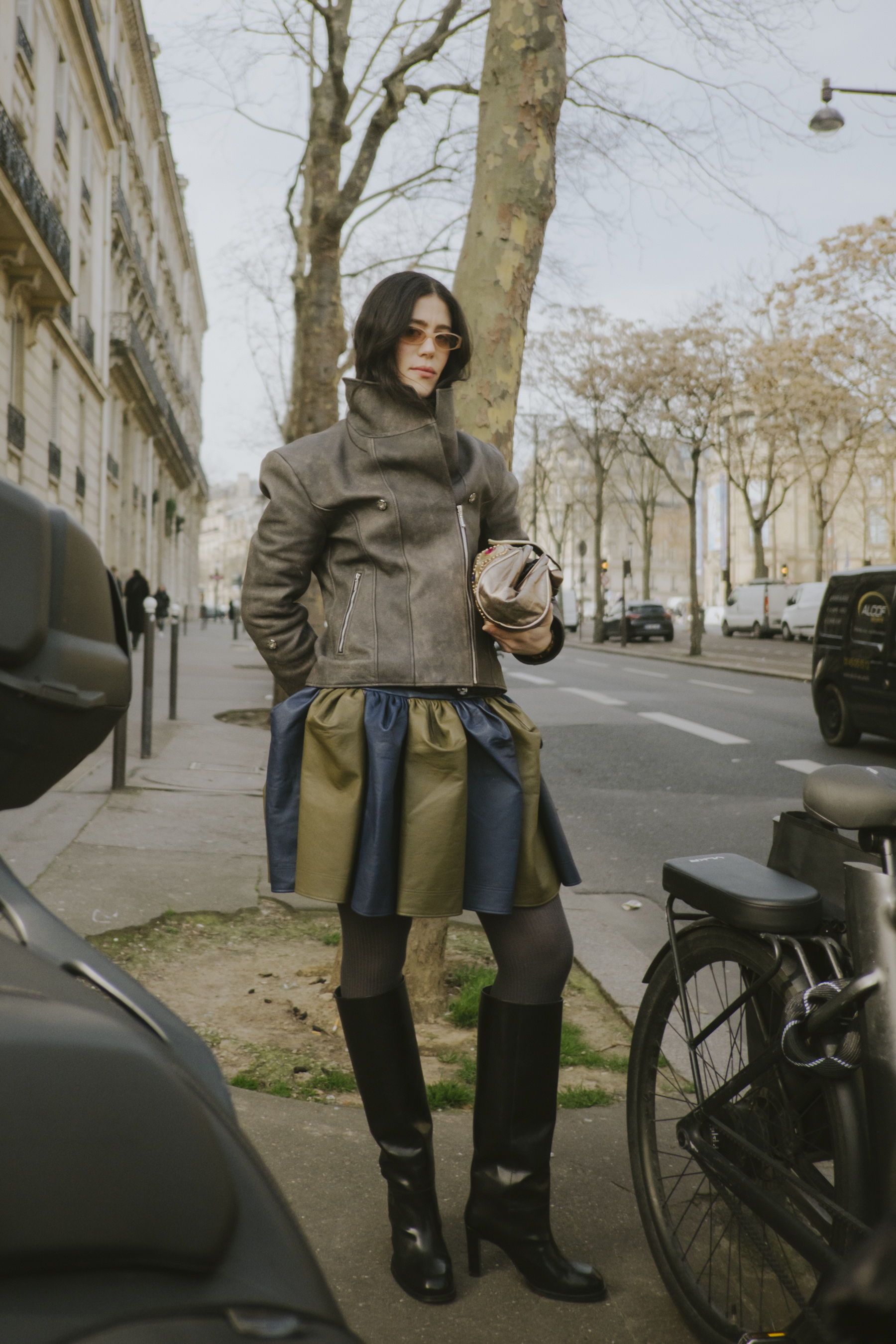 a woman wearing a gray leather funnel neck jacket at paris fashion week