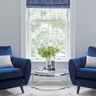 two blue armchairs beside a bedroom window