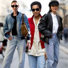 three women wear light-wash jeans in milan.