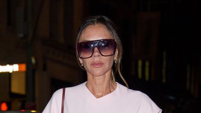 Victoria Beckham in a pastel pink dress and big sunglasses