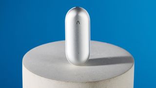 the plaud notepin, an AI dictaphone, in silver. it's a pill shaped device at just 2 inches long and can be worn as a watch, necklace, clip, or pin thanks to the magnetic panel