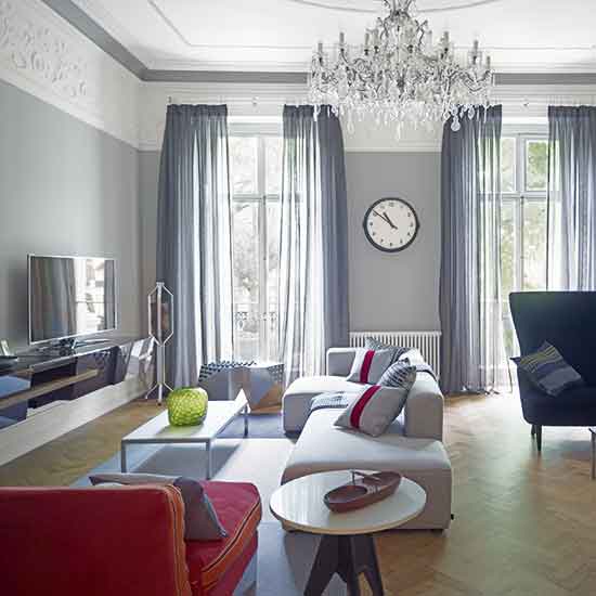 living room with chandelier and sofa with cushions and curtains on window
