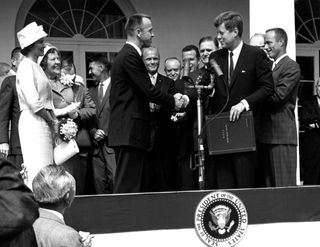 President John F. Kennedy congratulates astronaut Alan B. Shepard, Jr., the first American in space, on his historic May 5th, 1961 ride in the Freedom 7 spacecraft and presents him with the NASA Distinguished Service Award. The ceremony took place on the
