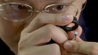 Man examining a diamond using the best loupe