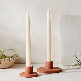 two simple taper candle holders in terracotta with a flat wide base