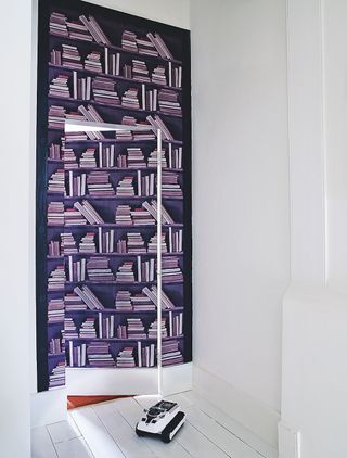 Secret door covered in book print wallpaper