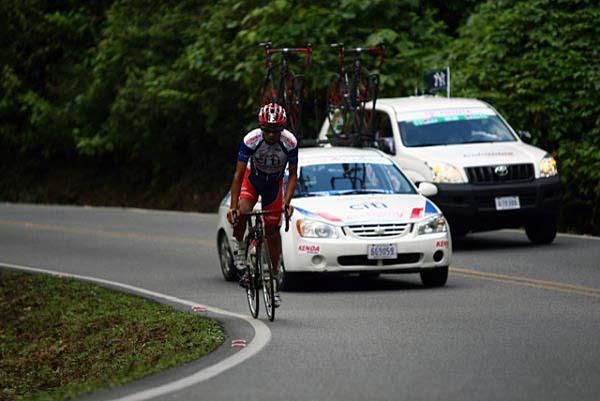 A Citibank-Economy Rent A Car-Blue stands on his pedals for a little extra momentum.