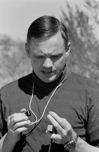 Astronaut Neil A. Armstrong, commander of the Apollo 11 prime crew, studies rock sample during a geological field trip to the Quitman Mountains area near the Fort Quitman ruins in far west Texas.