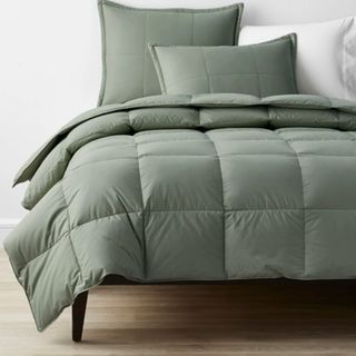 LaCrosse Premium Down Light Warmth Comforter in Thyme against a wall.
