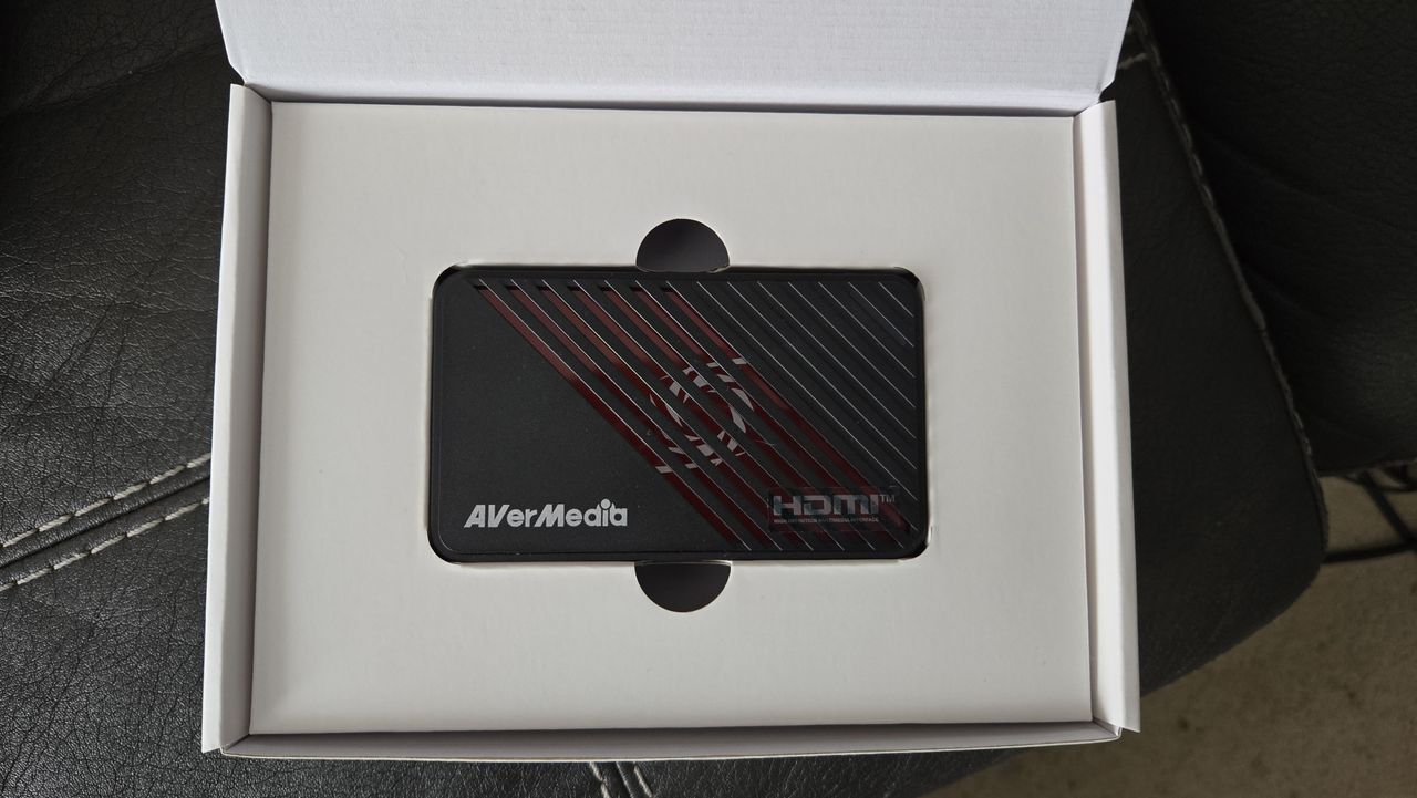 An AverMedia external capture card on a chair.