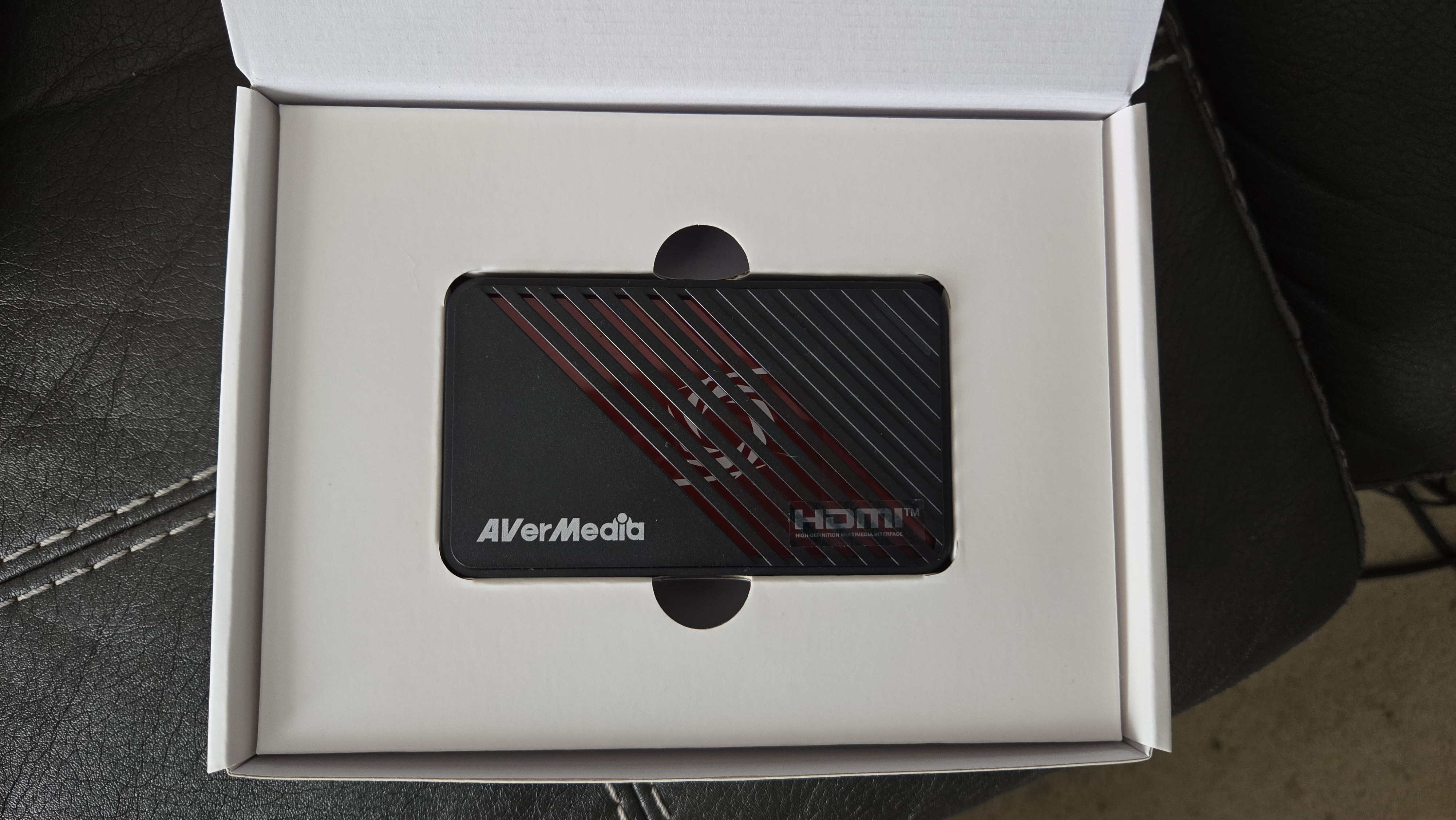 An AverMedia external capture card on a chair.