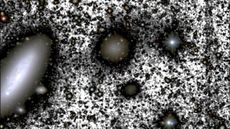 The galaxy DF4 (center). was originally a big problem for dark matter researchers, having little dark matter at all. But in 2020 astronomers cracked its mystery.