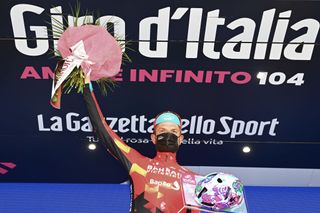 VALLE SPLUGA ALPE MOTTA ITALY MAY 29 Damiano Caruso of Italy and Team Bahrain Victorious celebrates at podium during the 104th Giro dItalia 2021 Stage 20 a 164km stage from Verbania to Valle Spluga Alpe Motta 1727m Kask Utopia Giro Helmet designed by MotoGP artist Aldo Drudi to stage winners The peloton passing through flowery landscape UCIworldtour girodiitalia Giro on May 29 2021 in Valle Spluga Alpe Motta Italy Photo by Stuart FranklinGetty Images
