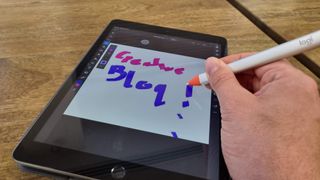 Logitech Crayon stylus and iPad on wooden desk