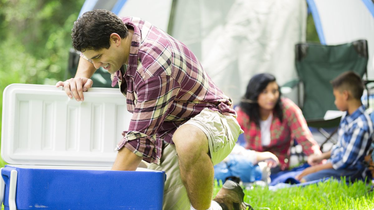 A camper reaches into the cooler