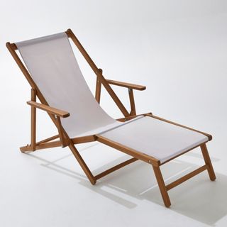 A wooden deckchair with extended leg section and white material upholstery.