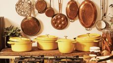 A range of Staub Citron cocottes in a French-style kitchen with hanging copper pans