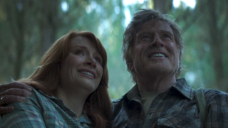 Bryce Dallas Howard and Robert Redford smiling together in a forest in Pete's Dragon