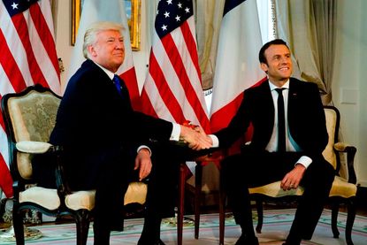 Trump and Emmanuel Macron shake hands, fiercly