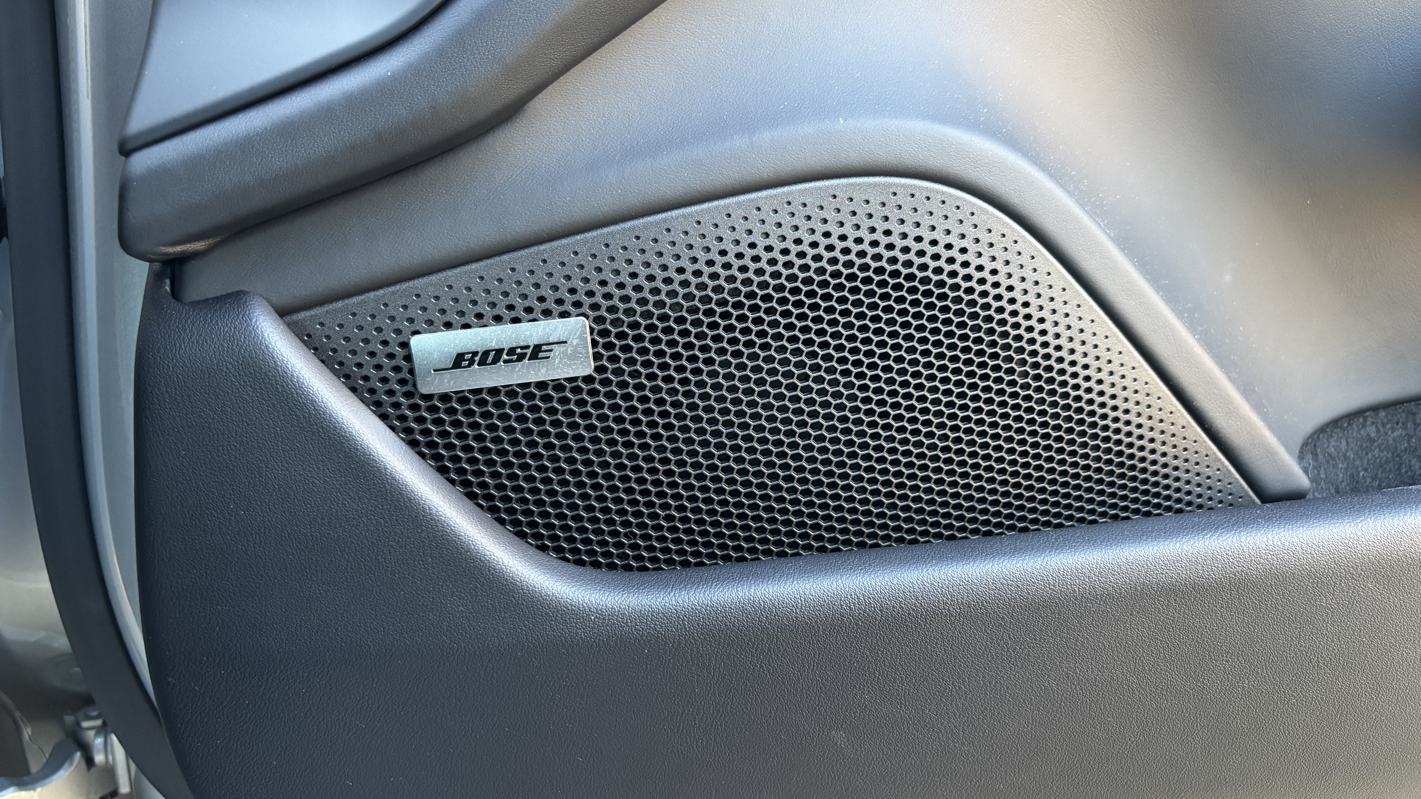 Porsche Taycan speaker grille with the Bose logo on it
