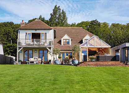 house with open lawn area and white wall