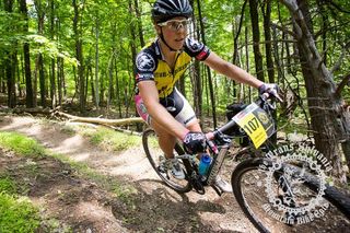 Amanda Carey rides a wide corner through the woods.