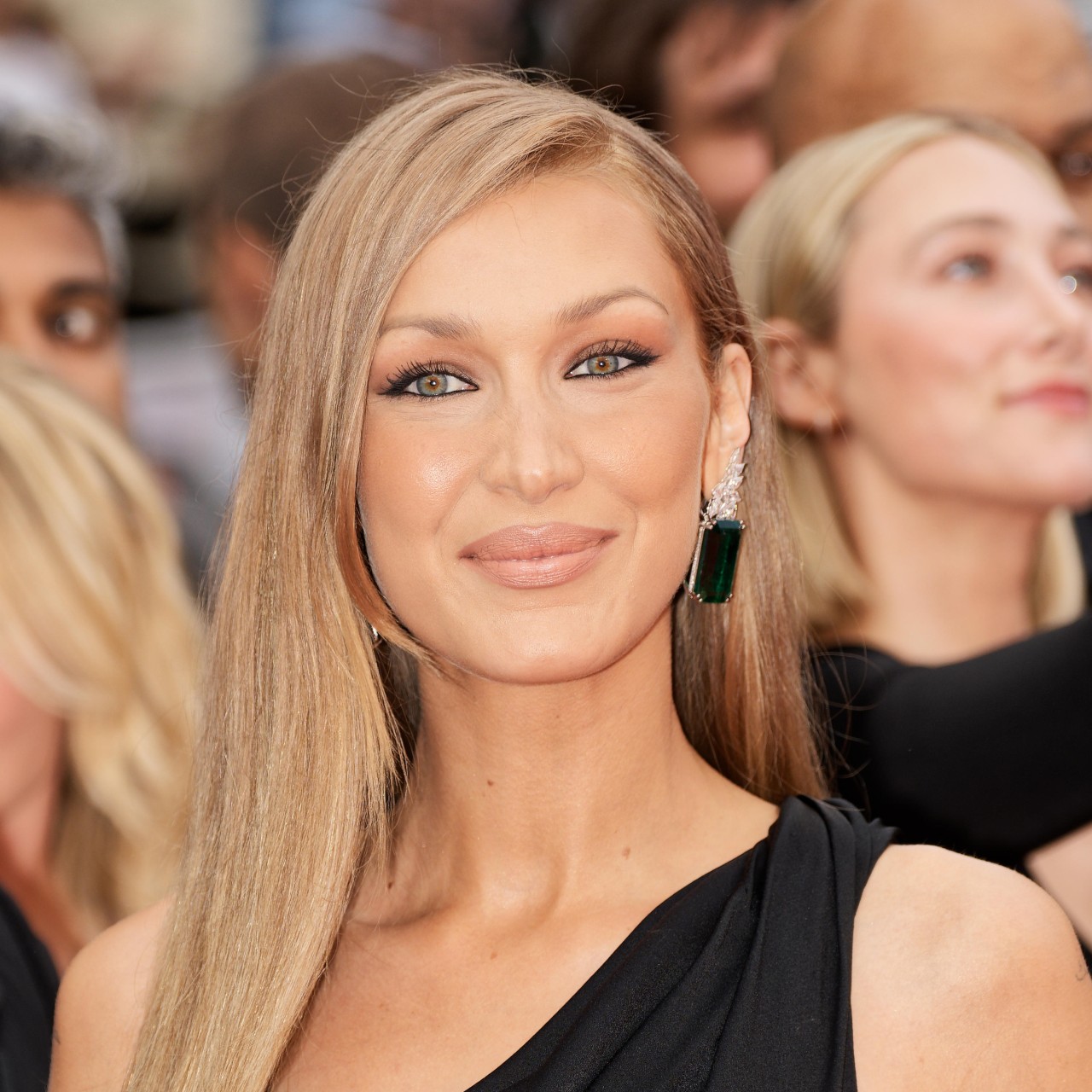 a white woman with blonde hair posing in front of a crowd on a red carpet