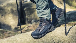 Person wearing hiking boots walking with trekking poles