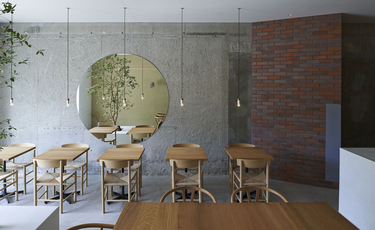 Tables &amp; chairs in restaurant with hanging lights above