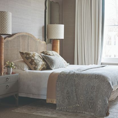 Neutral bedroom with rattan headboard and large matching bedside lamps