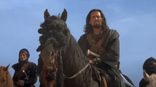 Oded Fehr leads on horseback in the desert in The Mummy Returns.