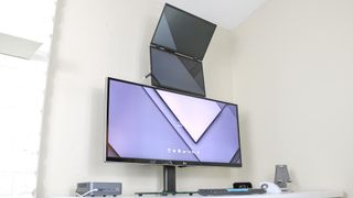 An ultrawide monitor with a folding, dual-display portable monitor stacked on top of it on a desk