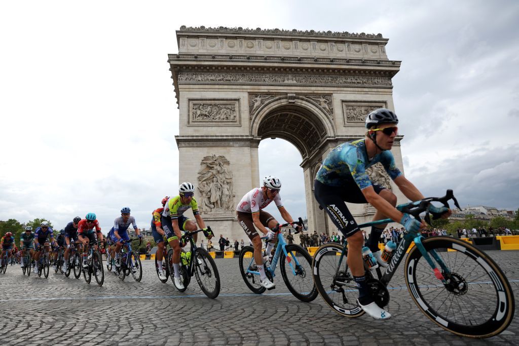 The pack cycles past the Arc de Triomphe on Place de l&rsquo;Etoile