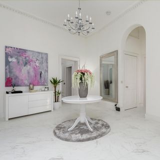 hallway with white wall white round table childminder and white flooring