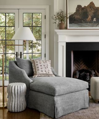 cozy fireplace with a chaise lounge armchair and a floor lamp and side table