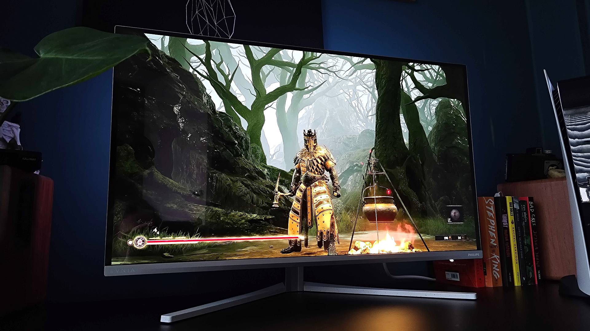 Philips Evnia 32M2N8900 on black desk with Mortal Shell gameplay on screen.