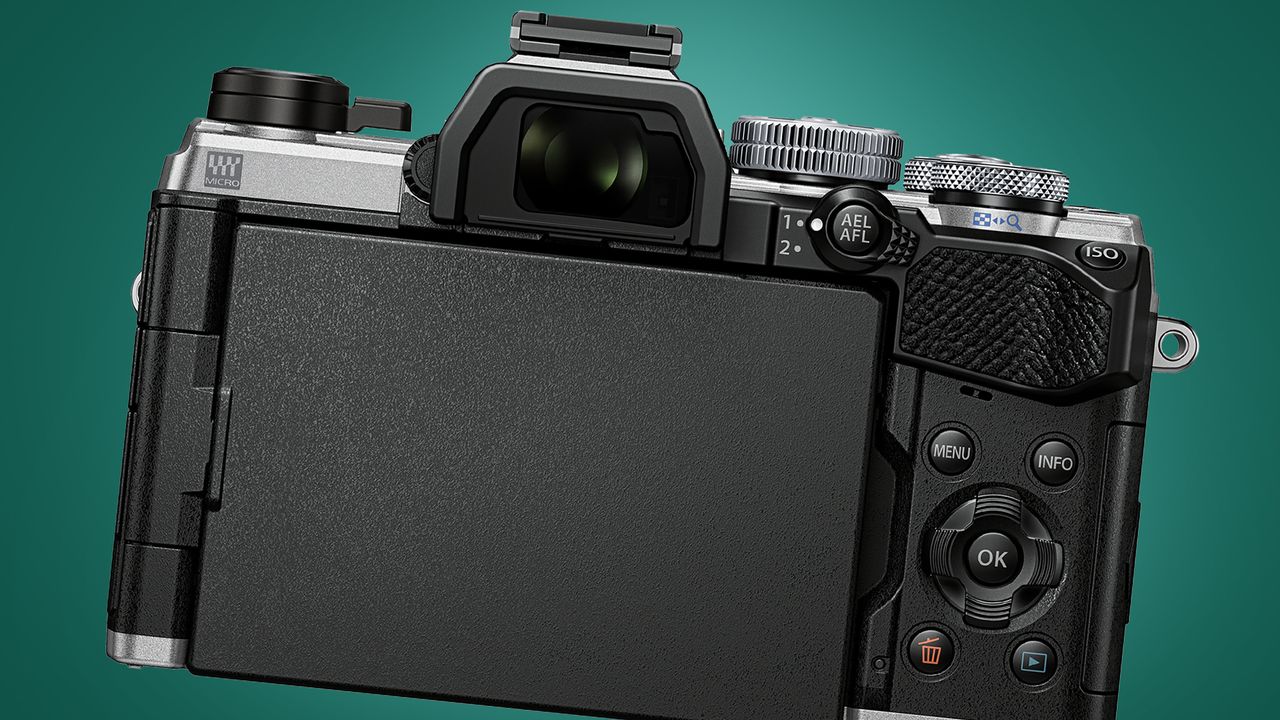 The OM System OM-5 camera on a green background