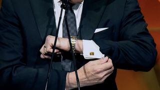 Jim Nantz holds up his cufflink at the B+C Hall of Fame evening