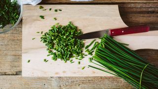 chives on a chopping board, half chopped