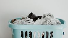 Mint green laundry basket with clothes in it