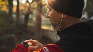Man looking at fitness tracker in early morning light