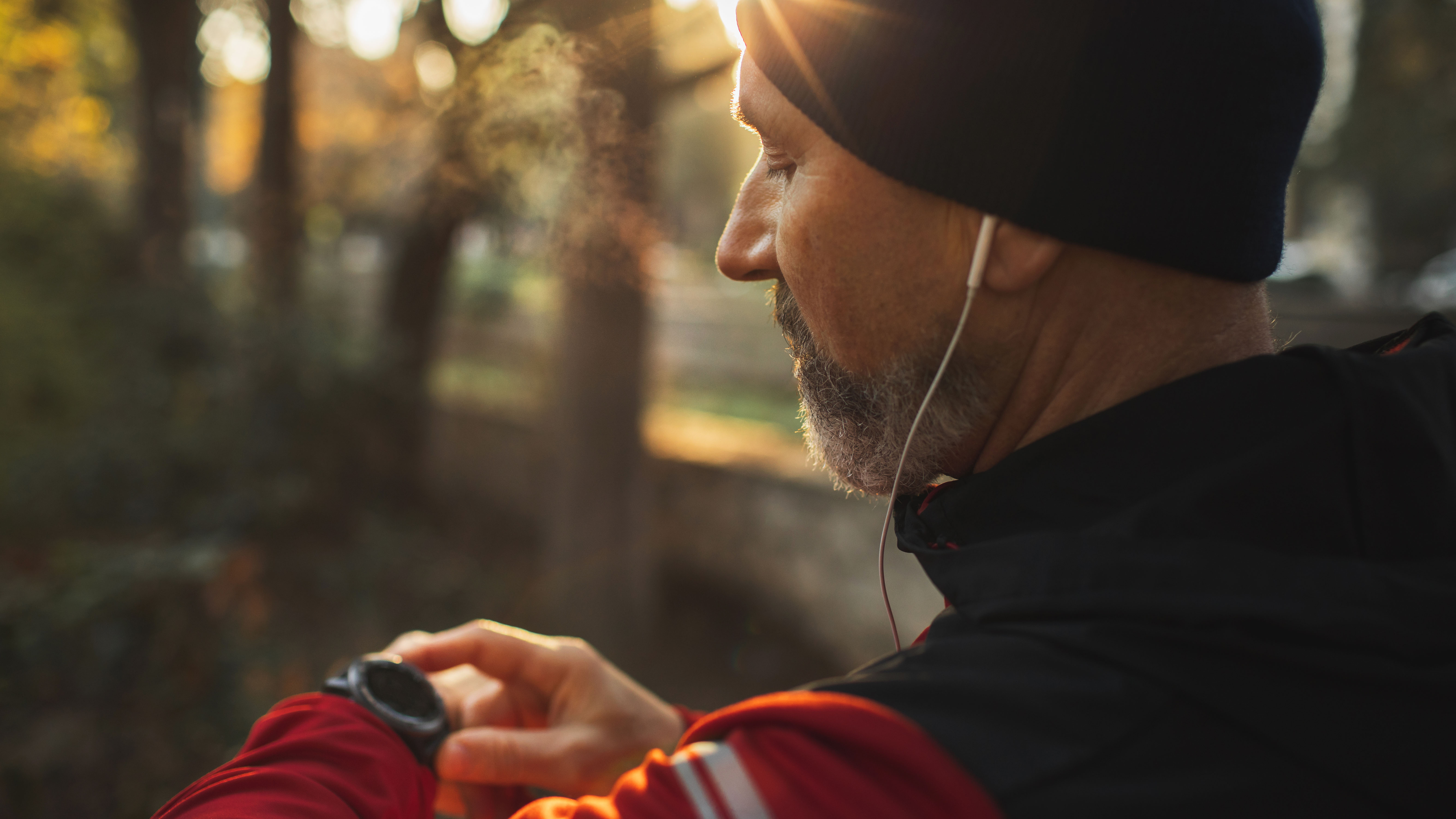 Hombre mirando el rastreador de fitness a primera hora de la mañana