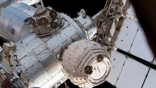 photo of a cylindrical white space habitat attached to the exterior of the international space station