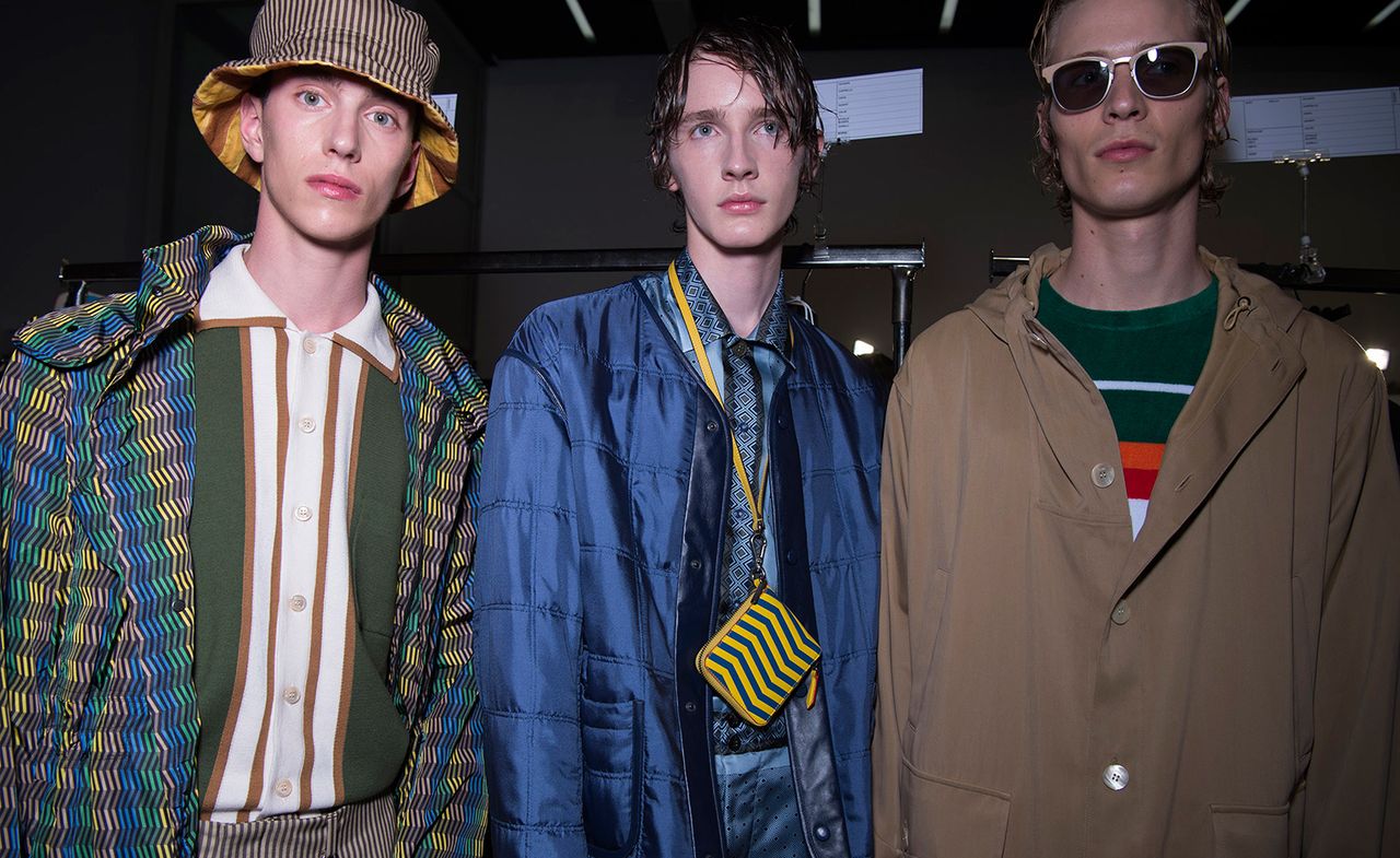 Three models pose for a picture in a dark room