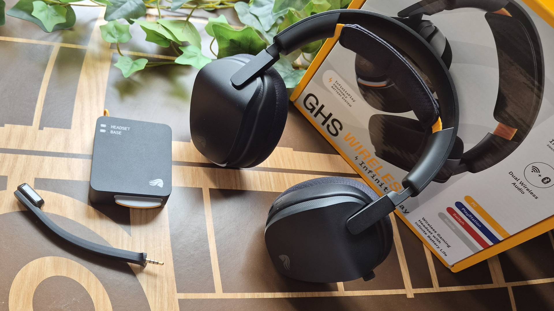 Photo of the Glorious GHS Wireless InfinitePlay headset on a wooden table.
